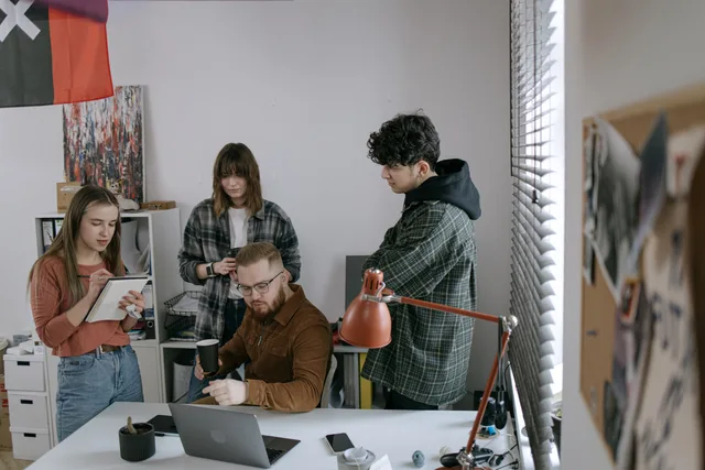 Group of young professionals having a team meeting around a laptop in a modern startup office. Så skalar du ett växande bolag